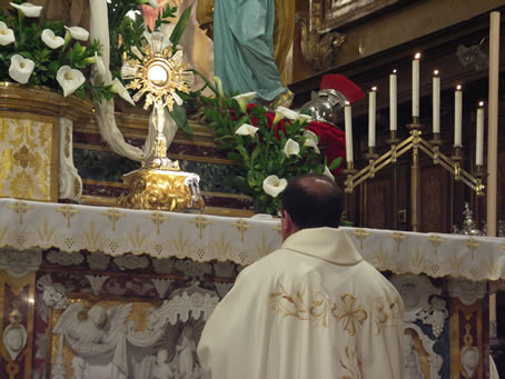 D9 Archpriest kneels in front of the Blessed Sacrament