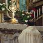 D9 Archpriest kneels in front of the Blessed Sacrament