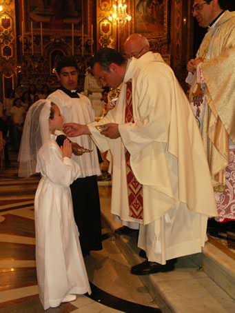 I4 Fr Charles Sultana gives Holy Communion to a relative