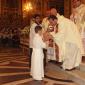 G7 Fr Joe Bajada hands Holy Communion to a relative