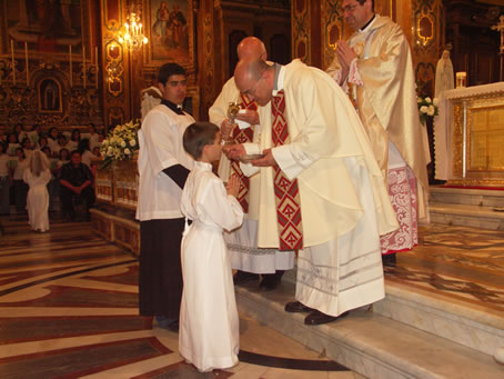 H3 Fr George Buttigieg gives Holy Communion to his nephew