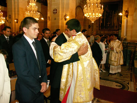 H5 Deacon Curmi embraces his parents with the sign of peace