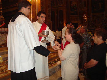 B1 Rev Joseph Curmi distributing Holy Communion