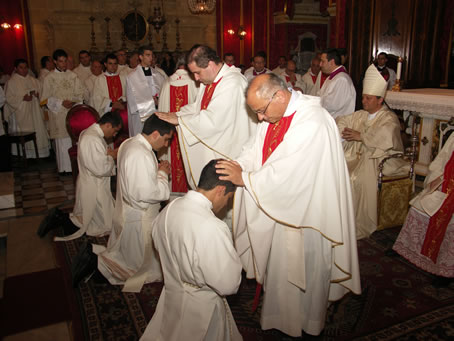 D7 Archpriest Can F Bajada lays hands on Fr Curmi's head