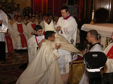 H2 Bishop embraces Fr Bajada