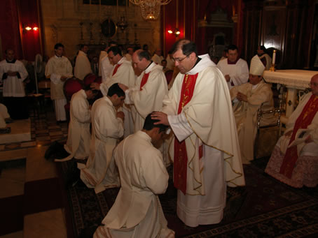 E3 Xaghra Archpriest Refalo with hands on Fr Bajada's head