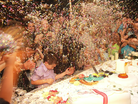 P9 Under showering confetti Fr Richard cuts the cake