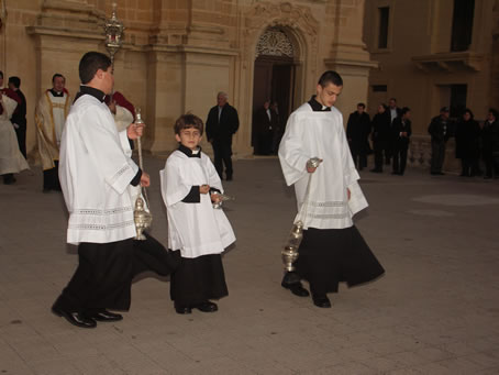 B1 Two altar boys precede the Holy Eucharist