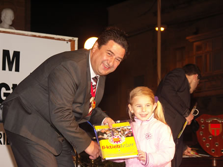 G8 Mayor presents books to a toddler