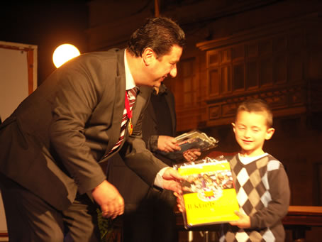 H3 Mayor presents books to a toddler