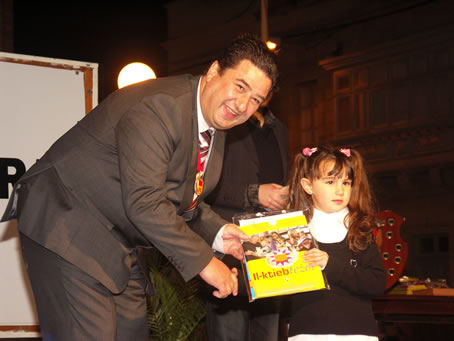 H2 Mayor presents books to a toddler