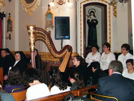 D3 Choir Director Mario Xerri sits next to harp