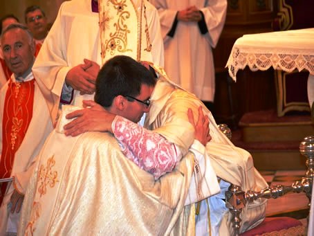 103 Bishop embraces new priest Fr Daniel Grech