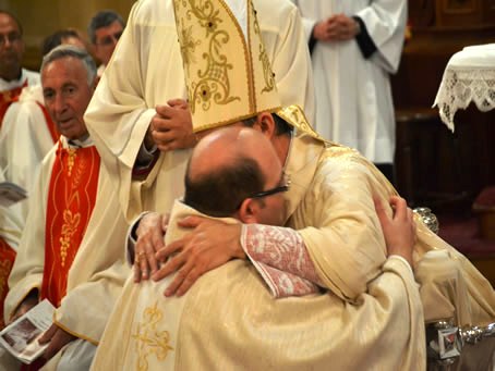 100 Bishop embraces new priest Fr Mark Bonello