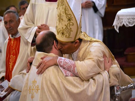 101 Bishop embraces new priest Fr Mark Bonello