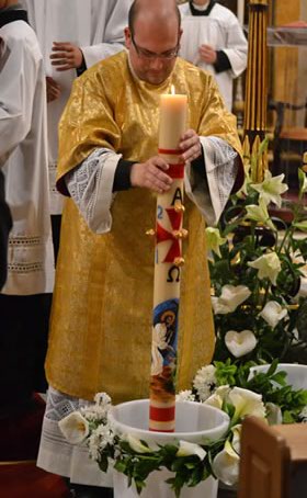 063 Deacon dipping the Paschal Candle in the water