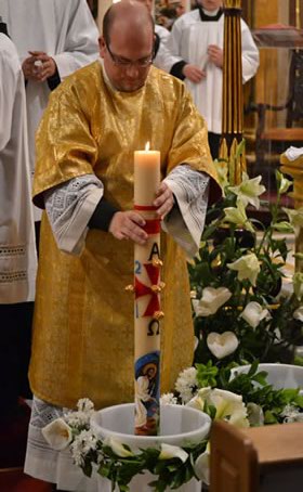 064 Deacon dipping the Paschal Candle in the water