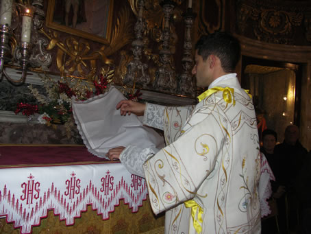 B8 Deacon Bajada approaches the covered statue of Jesus